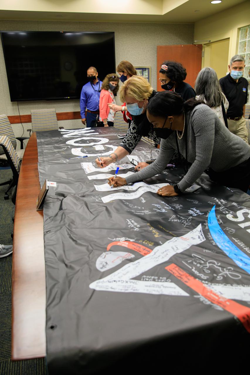 Senior leaders with Kennedy Space Center in Florida, familiarize newly appointed officials from NASA Headquarters with the center’s facilities during a tour on April 19, 2021. The group is inside the Neil Armstrong Operations and Checkout Building signing an Artemis banner. Artemis I will be the first integrated test of SLS and Orion and will pave the way for landing the first woman and first person of color on the lunar surface. It will be a proving ground for deep space exploration, leading the agency’s efforts under the Artemis program for a sustainable presence on the Moon and preparing for human missions to Mars. 