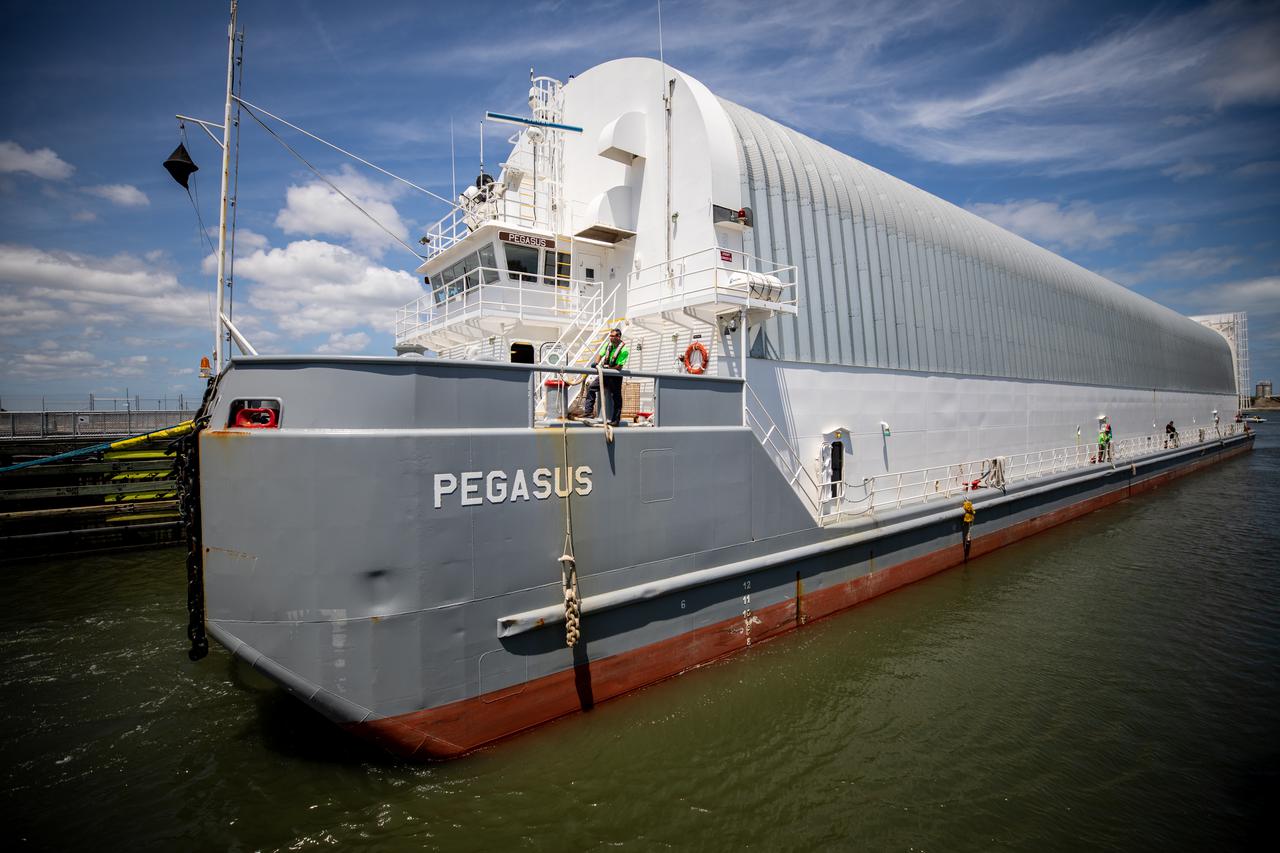The Pegasus barge, carrying the mighty Space Launch System (SLS) core stage, passes through Port Canaveral on its way to NASA’s Kennedy Space Center in Florida on April 27, 2021, after journeying from the agency’s Stennis Space Center in Mississippi. The core stage is the final piece of Artemis hardware to arrive at the spaceport and will be offloaded and moved to Kennedy’s Vehicle Assembly Building, where it will be prepared for integration atop the mobile launcher with the completed stack of solid rocket boosters ahead of the Artemis I launch. The first in a series of increasingly complex missions, Artemis I will test SLS and Orion as an integrated system prior to crewed flights to the Moon.