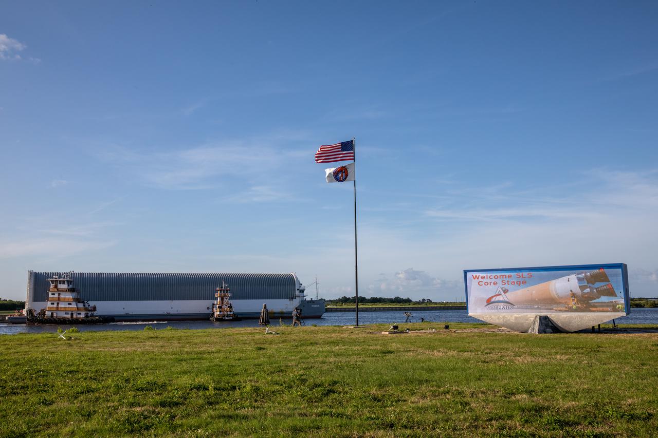 After its journey from NASA’s Stennis Space Center in Mississippi aboard the Pegasus barge, the mighty Space Launch System (SLS) core stage arrives at the agency’s Kennedy Space Center in Florida on April 27, 2021. In view is the iconic countdown clock at the NASA News Center, commonly referred to as the Press Site. The core stage is the final piece of Artemis hardware to arrive at the spaceport and will be offloaded and moved to Kennedy’s Vehicle Assembly Building, where it will be prepared for integration atop the mobile launcher with the completed stack of solid rocket boosters ahead of the Artemis I launch. The first in a series of increasingly complex missions, Artemis I will test SLS and Orion as an integrated system prior to crewed flights to the Moon.