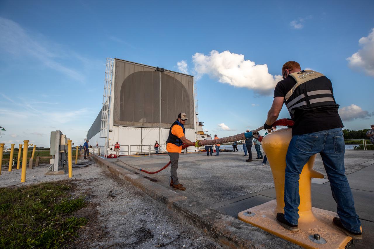 After its journey from NASA’s Stennis Space Center in Mississippi aboard the Pegasus barge, the mighty Space Launch System (SLS) core stage arrives at the agency’s Kennedy Space Center in Florida on April 27, 2021. In view is the iconic countdown clock at the NASA News Center, commonly referred to as the Press Site. The core stage is the final piece of Artemis hardware to arrive at the spaceport and will be offloaded and moved to Kennedy’s Vehicle Assembly Building, where it will be prepared for integration atop the mobile launcher with the completed stack of solid rocket boosters ahead of the Artemis I launch. The first in a series of increasingly complex missions, Artemis I will test SLS and Orion as an integrated system prior to crewed flights to the Moon.
