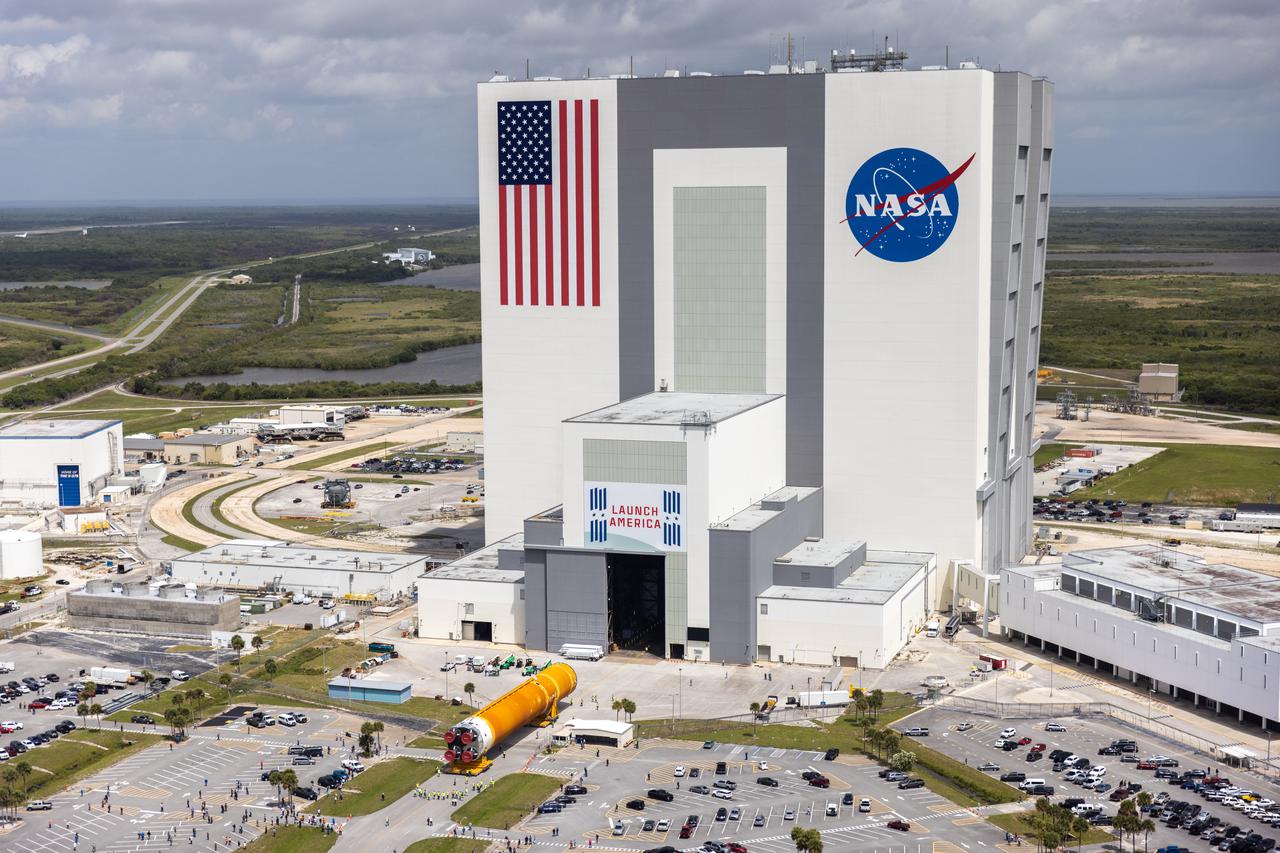 After completing its journey from NASA’s Stennis Space Center in Mississippi aboard the Pegasus barge, teams with Exploration Ground Systems (EGS) and lead contractor Jacobs transport the massive Space Launch System (SLS) core stage to Kennedy Space Center’s Vehicle Assembly Building in Florida on April 29, 2021 in this aerial view. Once inside the VAB, it will be prepared for integration with the completed stack of solid rocket boosters atop the mobile launcher ahead of the Artemis I launch. The first in a series of increasingly complex missions, Artemis I will test SLS and Orion as an integrated system prior to crewed flights to the Moon.
