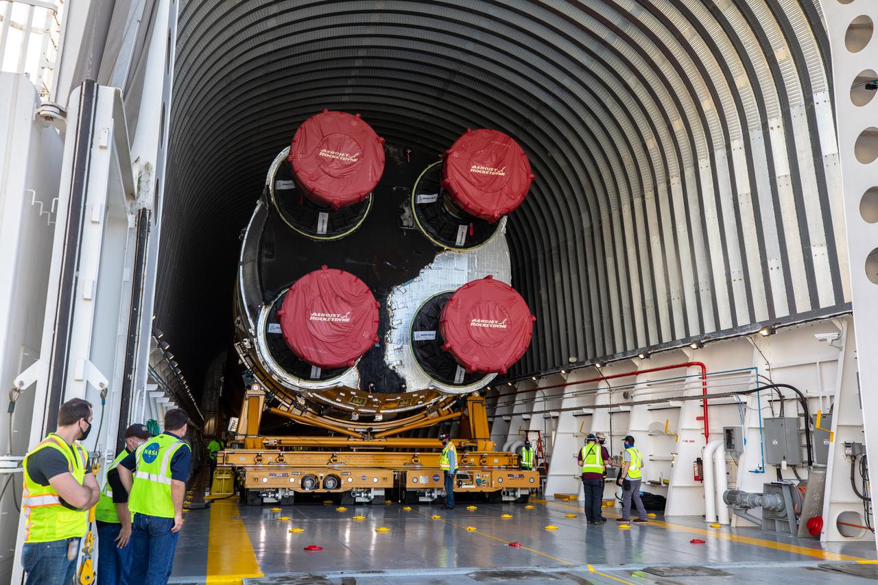 The massive 212-foot long Space Launch System (SLS) core stage is shown being offloaded from the Pegasus Barge on April 29, 2021, after arriving at NASA’s Kennedy Space Center in Florida. Teams with Exploration Ground Systems (EGS) and lead contractor Jacobs will transfer the rocket stage to the center’s Vehicle Assembly Building to prepare it for integration with the completed stack of solid rocket boosters atop the mobile launcher ahead of the Artemis I launch. The first in a series of increasingly complex missions, Artemis I will test SLS and Orion as an integrated system prior to crewed flights to the Moon.