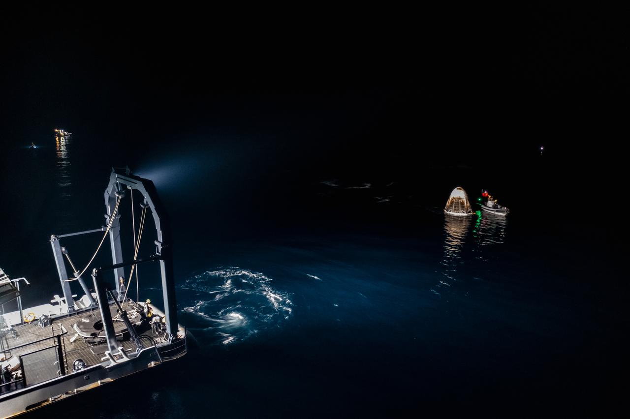 The SpaceX Crew Dragon Resilience splashes down in the Gulf of Mexico off the coast of Panama City, in Florida, at 2:56 a.m. EDT on May 2, 2021. Astronauts Michael Hopkins, Victor Glover, and Shannon Walker of NASA, and Soichi Noguchi of JAXA (Japan Aerospace Exploration Agency) completed Crew-1, the first crew rotation mission to the International Space Station in partnership with NASA as part of the agency’s Commercial Crew Program. At left is SpaceX’s Go Navigator recovery ship. Crew Dragon will be secured and then hoisted onto the main deck of the recovery ship with the astronauts inside.
