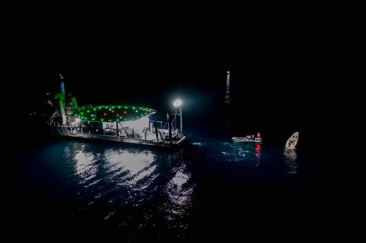 The SpaceX Crew Dragon Resilience splashes down in the Gulf of Mexico off the coast of Panama City, in Florida, at 2:56 a.m. EDT on May 2, 2021. Astronauts Michael Hopkins, Victor Glover, and Shannon Walker of NASA, and Soichi Noguchi of JAXA (Japan Aerospace Exploration Agency) completed Crew-1, the first crew rotation mission to the International Space Station in partnership with NASA as part of the agency’s Commercial Crew Program. At left is SpaceX’s Go Navigator recovery ship. Teams on two fast boats and Go Navigator will secure Crew Dragon to be hoisted onto the main deck of the recovery ship with the astronauts inside.