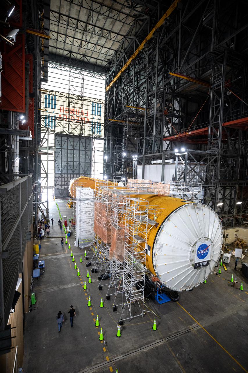 The Space Launch System (SLS) core stage for NASA’s Artemis I mission is in the transfer aisle of the Vehicle Assembly Building at Kennedy Space Center in Florida on May 5, 2021. Teams from the center’s Exploration Ground Systems and contractor Jacobs will perform checkouts ahead of integrating the massive rocket stage with the twin solid rocket boosters, Orion spacecraft, and additional flight hardware ahead of the Artemis I launch. Artemis I will be the first integrated test of SLS and Orion and will pave the way for landing the first woman and first person of color on the lunar surface. It will be a proving ground for deep space exploration, leading the agency’s efforts under the Artemis program for a sustainable presence on the Moon and preparing for human missions to Mars. 