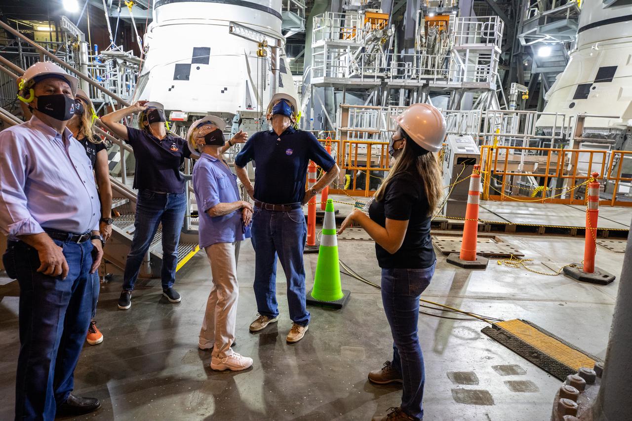 From left to right, Jim Keys, Pilot; Christina Korp, Assistant to Charlie Duke; Nicole Stott, NASA Astronaut (former); Dottie Duke, wife of Charlie Duke, Charlie Duke, NASA Astronaut (former); and Lili Villareal, Operations Flow Manager, Exploration Ground Systems tour the inside of the Vehicle Assembly Building (VAB) during a visit to NASA’s Kennedy Space Center in Florida on May 10, 2021. Visible in the background are the aft booster segments for the Space Launch System. The first in a series of increasingly complex missions, Artemis I will test Orion and SLS as an integrated system prior to crewed flights to the Moon.