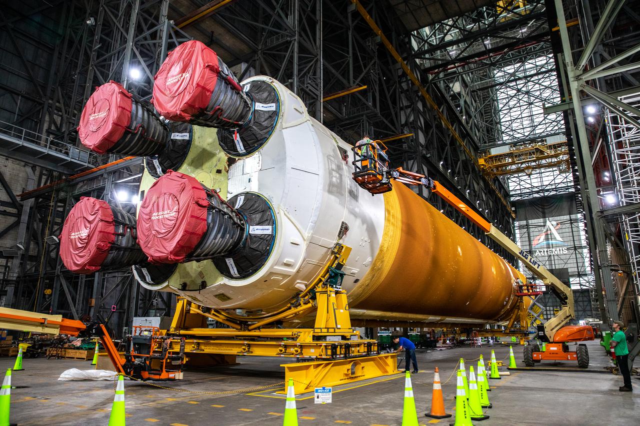 The Space Launch System (SLS) core stage is seen in the transfer aisle of the Vehicle Assembly Building (VAB) at NASA’s Kennedy Space Center in Florida on June 4, 2021. Teams with the agency’s Exploration Ground Systems and contractor Jacobs are preparing to lift the 188,000-pound core stage and place it on the mobile launcher in between the two solid rocket boosters in High Bay 3 of the VAB. The core stage alone will provide more than 2 million pounds of thrust at launch, and coupled with the boosters, will provide more than 8.8 million pounds of thrust to launch the Artemis I mission. The first in an increasingly complex series of missions, Artemis I will test SLS and the Orion spacecraft as an integrated system ahead of crewed flights to the Moon.