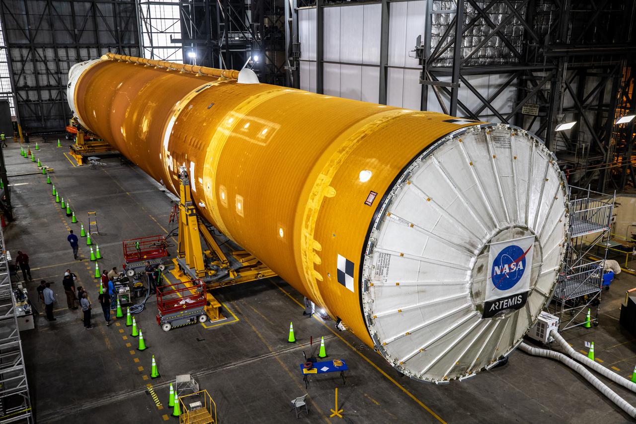 The Space Launch System (SLS) core stage is seen in the transfer aisle of the Vehicle Assembly Building (VAB) at NASA’s Kennedy Space Center in Florida on June 4, 2021. Teams with the agency’s Exploration Ground Systems and contractor Jacobs are preparing to lift the 188,000-pound core stage and place it on the mobile launcher in between the two solid rocket boosters in High Bay 3 of the VAB. The core stage alone will provide more than 2 million pounds of thrust at launch, and coupled with the boosters, will provide more than 8.8 million pounds of thrust to launch the Artemis I mission. The first in an increasingly complex series of missions, Artemis I will test SLS and the Orion spacecraft as an integrated system ahead of crewed flights to the Moon.
