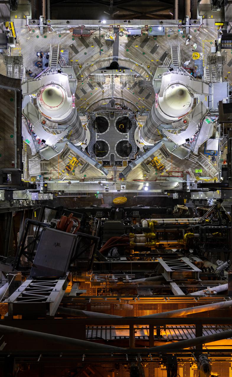 In this view looking down from inside High Bay 3 of the Vehicle Assembly Building (VAB) at NASA’s Kennedy Space Center in Florida on June 9, 2021, the fully stacked twin solid rocket boosters for the agency’s Space Launch System (SLS) rocket sit atop the mobile launcher. Teams with NASA’s Exploration Ground Systems and contractor Jacobs are making final preparations to integrate the boosters with the SLS core stage, which arrived at Kennedy in April 2020. Manufactured by Northrop Grumman in Utah, the twin boosters provide more than 75 percent of the total SLS thrust at launch. When integrated, the 212-foot, 188,000-pound core stage and twin boosters will provide more than 8.8 million pounds of thrust to launch Artemis I. The first in an increasingly complex series of missions, Artemis I will test SLS and the Orion spacecraft as an integrated system ahead of crewed flights in which NASA will land the first woman and person of color on the Moon.