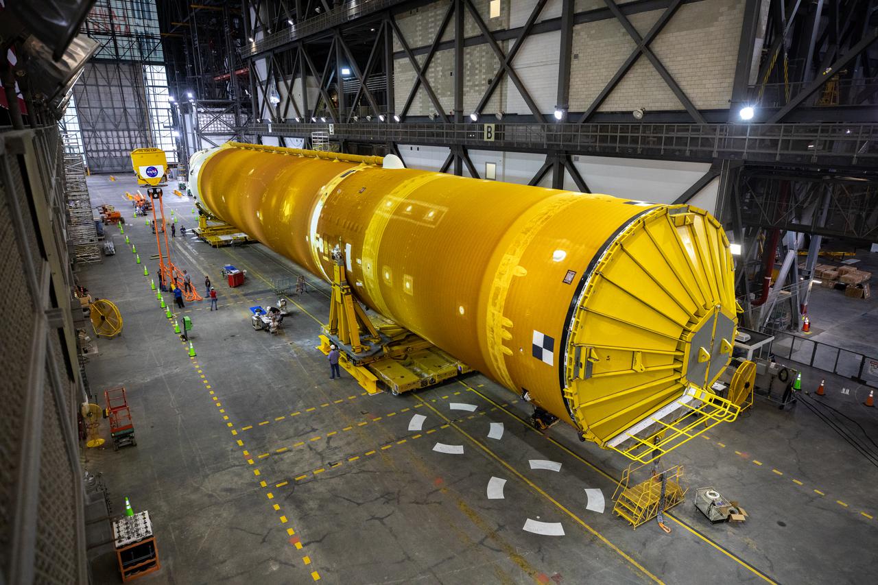 The Space Launch System (SLS) core stage is seen in the transfer aisle of the Vehicle Assembly Building (VAB) at NASA’s Kennedy Space Center in Florida on June 9, 2021. Teams with the agency’s Exploration Ground Systems and contractor Jacobs are preparing to lift the 188,000-pound core stage, which is the largest part of the rocket, and place it on the mobile launcher in between the two solid rocket boosters in High Bay 3 of the VAB. The core stage alone, with its four RS-25 engines, will provide more than 2 million pounds of thrust during launch and ascent, and coupled with the boosters, will provide more than 8.8 million pounds of thrust to send the Artemis I mission to space. The first in an increasingly complex series of missions, Artemis I will test SLS and the Orion spacecraft as an integrated system ahead of crewed flights to the Moon.
