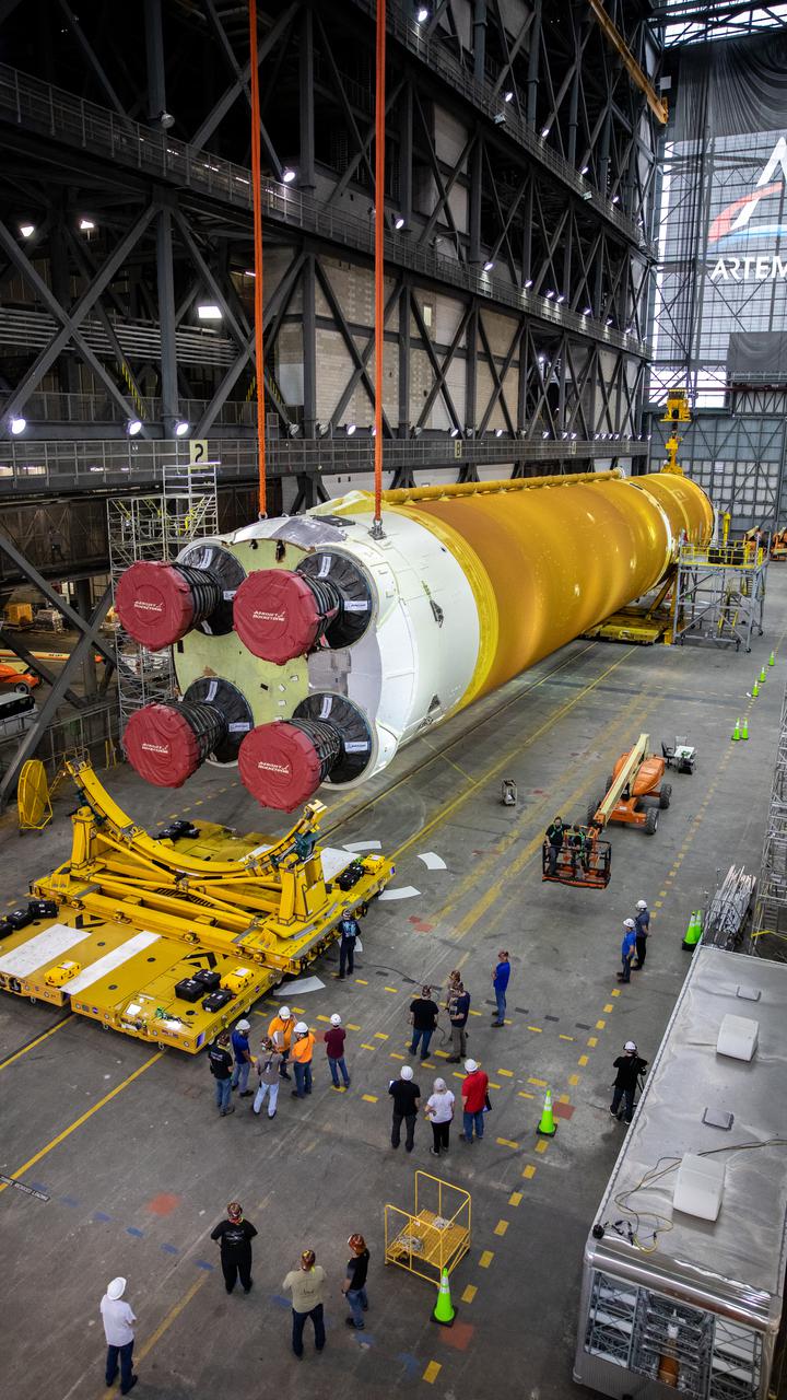 The Space Launch System (SLS) core stage is seen in the transfer aisle of the Vehicle Assembly Building (VAB) at NASA’s Kennedy Space Center in Florida on June 10, 2021. Teams with the agency’s Exploration Ground Systems and contractor Jacobs are preparing to lift the 188,000-pound core stage and place it on the mobile launcher in between the two solid rocket boosters in High Bay 3 of the VAB. The core stage alone will provide more than 2 million pounds of thrust at launch, and coupled with the boosters, will provide more than 8.8 million pounds of thrust to launch the Artemis I mission. The first in an increasingly complex series of missions, Artemis I will test SLS and the Orion spacecraft as an integrated system ahead of crewed flights to the Moon.