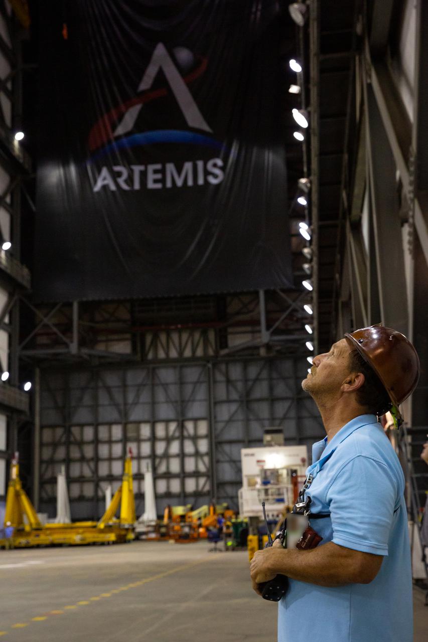 A Kennedy Space Center employee monitors operations as teams with the agency’s Exploration Ground Systems and contractor Jacobs lift the Space Launch System (SLS) core stage – the largest part of the rocket – and prepare to move it over to High Bay 3 in the Vehicle Assembly Building, where it will be placed atop the mobile launcher in between the twin solid rocket boosters, on June 11, 2021. The 188,000-pound core stage, with its four RS-25 engines, will provide more than 2 million pounds of thrust during launch and ascent, and coupled with the boosters, will provide more than 8.8 million pounds of thrust to send the Artemis I mission to space. Under the Artemis program, NASA will land the first woman and first person of color on the Moon, as well as establish a sustainable presence on the lunar surface in preparation for human missions to Mars.