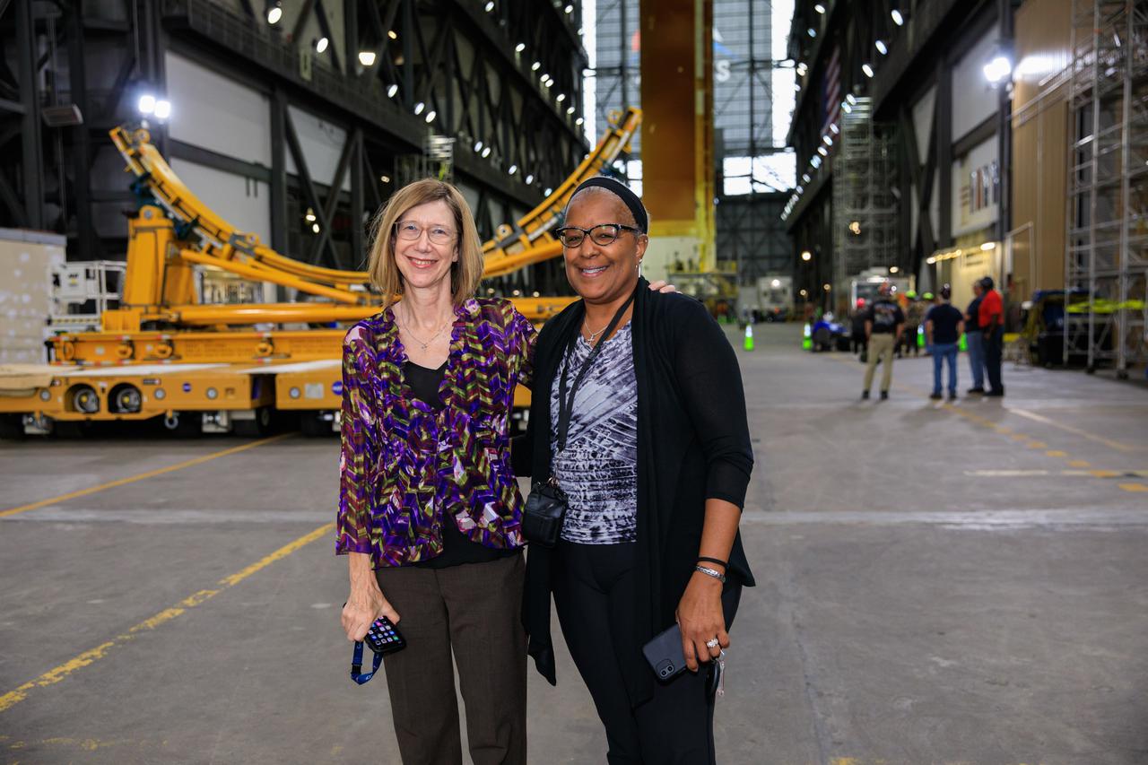 NASA Human Exploration and Operations (HEO) Deputy Associate Administrator Kathy Lueders (left) and HEO Deputy Associate Administrator for Management Altonell “Toni” Mumford (right) visit Kennedy Space Center's iconic Vehicle Assembly Building (VAB) in Florida on June 11, 2021. In the background, the core stage of NASA’s massive Space Launch System (SLS) rocket is visible in vertical position during lift and mate operations, prior to the core stage being moved and integrated with the twin solid rocket boosters atop the mobile launcher in High Bay 3 of the VAB. The 188,000-pound core stage, with its four RS-25 engines, will provide more than 2 million pounds of thrust during launch and ascent, and coupled with the boosters, will provide more than 8.8 million pounds of thrust to send the Artemis I mission to space. Under the Artemis program, NASA will land the first woman and first person of color on the Moon, as well as establish a sustainable presence on the lunar surface in preparation for human missions to Mars. 