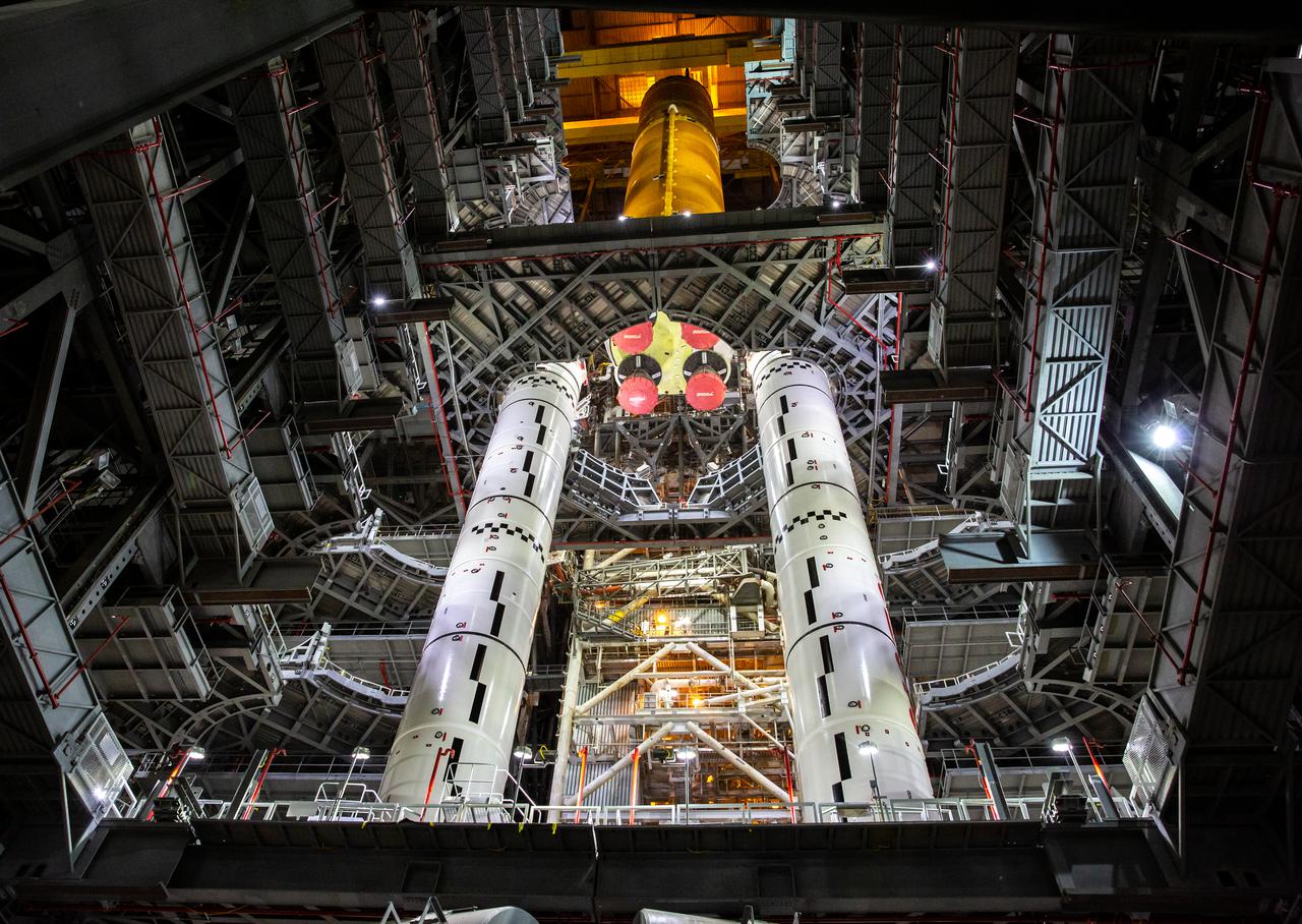 Teams with NASA’s Exploration Ground Systems and contractor Jacobs lower the Space Launch System (SLS) core stage – the largest part of the rocket – onto the mobile launcher, in between the twin solid rocket boosters, inside High Bay 3 of the Vehicle Assembly Building at NASA’s Kennedy Space Center in Florida on June 12, 2021. The 188,000-pound core stage, with its four RS-25 engines, will provide more than 2 million pounds of thrust during launch and ascent, and coupled with the boosters, will provide more than 8.8 million pounds of thrust to send the Artemis I mission to space. Under the Artemis program, NASA will land the first woman and first person of color on the Moon, as well as establish a sustainable presence on the lunar surface in preparation for human missions to Mars.
