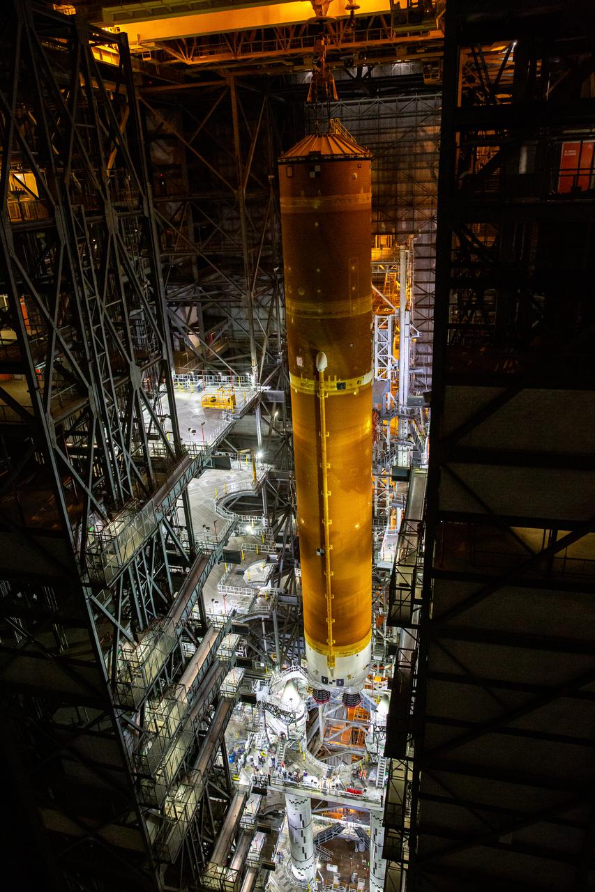 Teams with NASA’s Exploration Ground Systems and contractor Jacobs prepare to lower the Space Launch System (SLS) core stage – the largest part of the rocket – onto the mobile launcher, in between the twin solid rocket boosters, inside High Bay 3 of the Vehicle Assembly Building at NASA’s Kennedy Space Center in Florida on June 12, 2021. The 188,000-pound core stage, with its four RS-25 engines, will provide more than 2 million pounds of thrust during launch and ascent, and coupled with the boosters, will provide more than 8.8 million pounds of thrust to send the Artemis I mission to space. Under the Artemis program, NASA will land the first woman and first person of color on the Moon, as well as establish a sustainable presence on the lunar surface in preparation for human missions to Mars.
