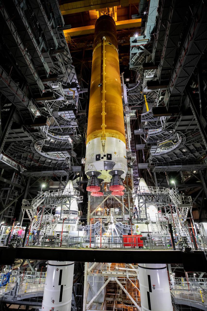 Teams with NASA’s Exploration Ground Systems and contractor Jacobs prepare to lower the Space Launch System (SLS) core stage – the largest part of the rocket – onto the mobile launcher, in between the twin solid rocket boosters, inside High Bay 3 of the Vehicle Assembly Building at NASA’s Kennedy Space Center in Florida on June 12, 2021. The 188,000-pound core stage, with its four RS-25 engines, will provide more than 2 million pounds of thrust during launch and ascent, and coupled with the boosters, will provide more than 8.8 million pounds of thrust to send the Artemis I mission to space. Under the Artemis program, NASA will land the first woman and first person of color on the Moon, as well as establish a sustainable presence on the lunar surface in preparation for human missions to Mars.