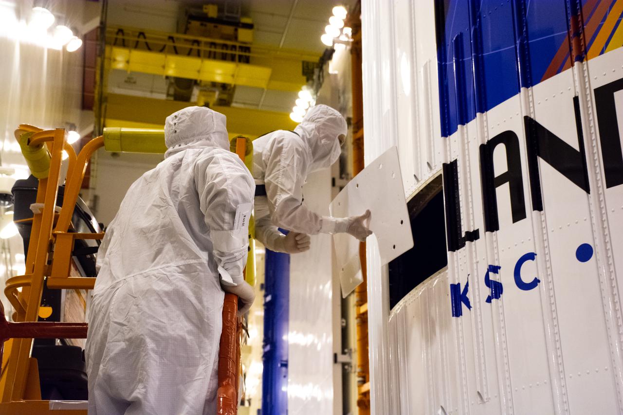 Inside the Integrated Processing Facility at Vandenberg Space Force Base in California, United Launch Alliance (ULA) technicians remove the access door from the two ULA Atlas V rocket payload fairings for NASA’s Landsat 9 satellite on June 24, 2021. The fairings will encapsulate the satellite for its launch atop the Atlas V from Vandenberg in September 2021. The launch is being managed by NASA’s Launch Services Program based at Kennedy Space Center in Florida. Landsat 9 will continue the nearly 50-year legacy of previous Landsat missions. It will monitor key natural and economic resources from orbit. Landsat 9 is managed by the agency’s Goddard Space Flight Center in Greenbelt, Maryland. It will carry two instruments: the Operational Land Imager 2, which collects images of Earth’s landscapes in visible, near-infrared and shortwave infrared light, and the Thermal Infrared Sensor 2, which measures the temperature of land surfaces. Like its predecessors, Landsat 9 is a joint mission between NASA and the U.S. Geological Survey.