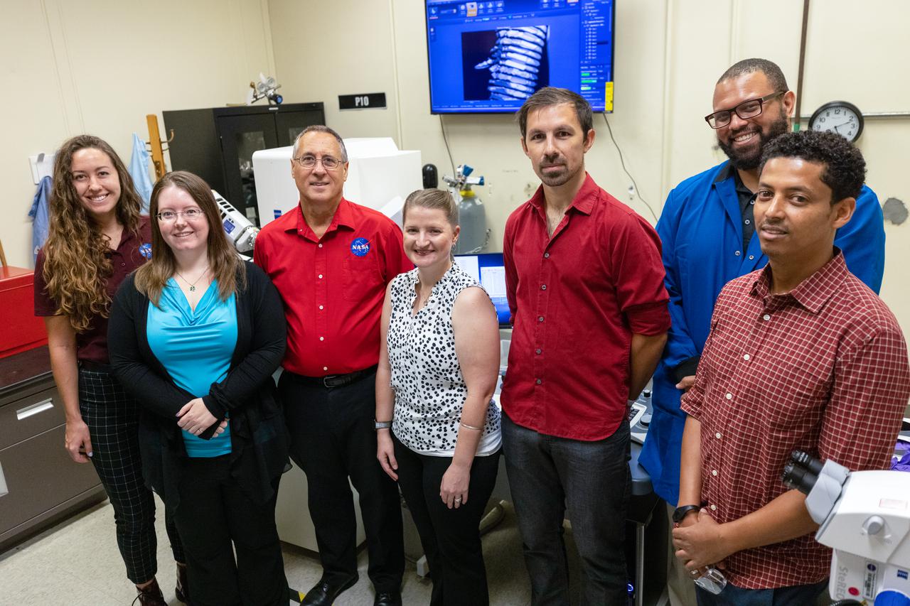 Chemists from NASA Engineering’s Analytical Laboratories at Kennedy Space Center in Florida pose for a photo near a scanning electron microscope on July 7, 2021. From left to right is Macy Mullen, structural materials; Athela Frandsen, structural materials; Philip Howard, lead, structural materials; Janelle Coutts, gas and fluid systems; David Rinderknecht, structural materials; Trey Barnes, Earth biosphere studies; and Misle Tessema, Earth biosphere studies. One of seven branches in the NASA Laboratories, Development, and Testing Division, the Analytical Laboratories branch provides microscopic imagery and analysis through the use of a wide variety of microscopic techniques to identify contaminants and other urgent problems associated with aerospace flight hardware, ground support equipment, and related facilities. 