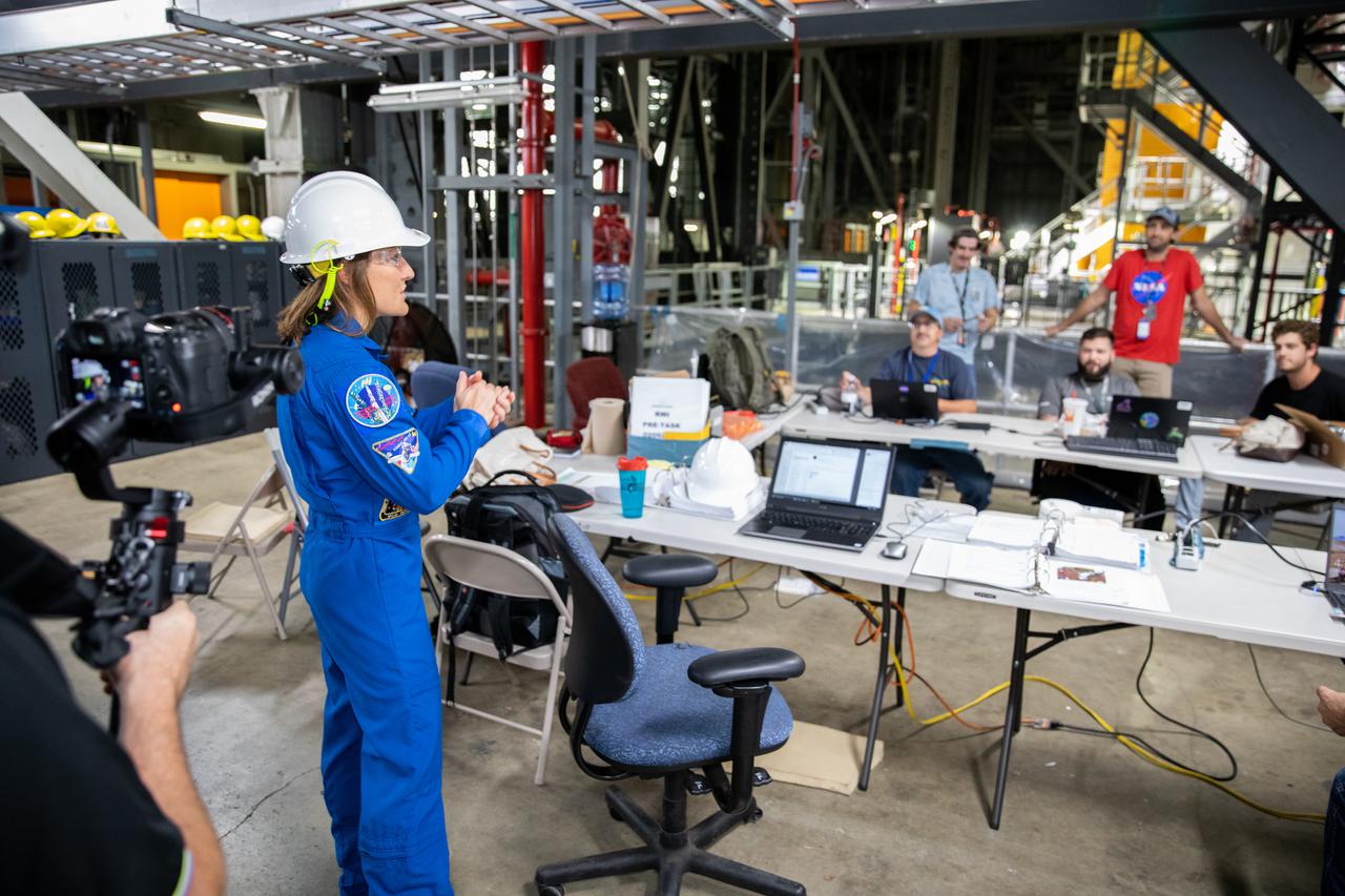 NASA astronaut Christina Koch stands inside Kennedy Space Center’s Vehicle Assembly Building on July 14, 2021, in front of the agency’s Space Launch System (SLS) rocket that will power the Orion spacecraft on the Artemis I mission later this year. Artemis I will be an uncrewed flight test of Orion and SLS as an integrated system ahead of missions with astronauts. Under Artemis, NASA aims to land the first woman and first person of color on the Moon and establish a long-lasting presence on and around the Moon while preparing for human missions to Mars.