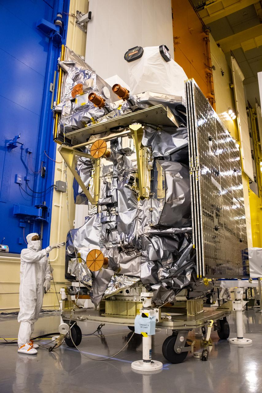 Inside the Integrated Processing Facility at Vandenberg Space Force Base in California, technicians begin to remove the protective cover from NASA’s Landsat 9 observatory on July 14, 2021. Landsat 9 will launch on a United Launch Alliance Atlas V rocket from Space Launch Complex 3 at Vandenberg in September 2021. The launch is being managed by NASA’s Launch Services Program based at Kennedy Space Center, America’s multiuser spaceport. The Landsat 9 satellite will continue the nearly 50-year legacy of previous Landsat missions. It will monitor key natural and economic resources from orbit. The satellite will carry two instruments: the Operational Land Imager 2, which collects images of Earth’s landscapes in visible, near infrared and shortwave infrared light, and the Thermal Infrared Sensor 2, which measures the temperature of land surfaces. Like its predecessors, Landsat 9 is a joint mission between NASA and the U.S. Geological Survey. Landsat 9 is managed by the agency’s Goddard Space Flight Center in Greenbelt, Maryland.