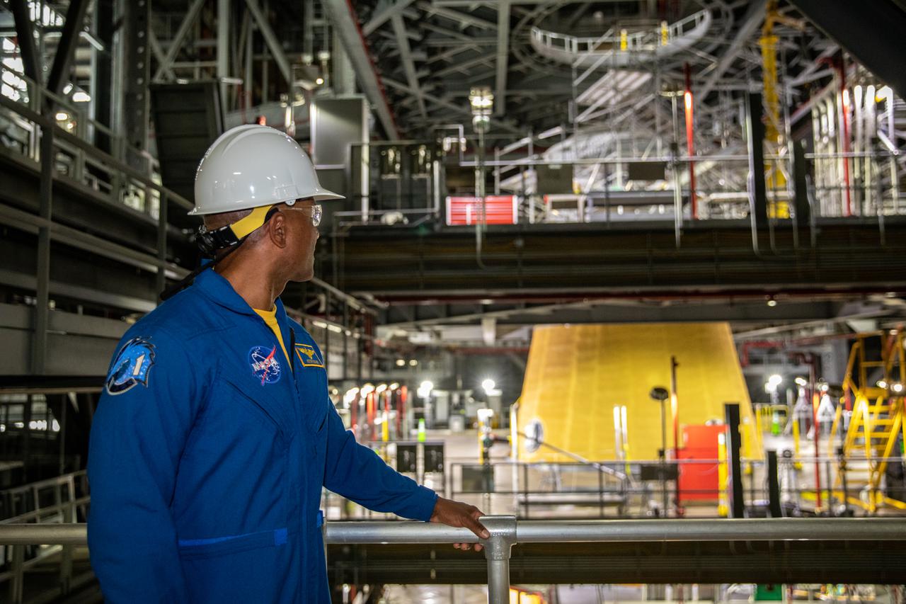 NASA astronaut Victor Glover stands inside Kennedy Space Center’s Vehicle Assembly Building on July 15, 2021, near the agency’s Space Launch System (SLS) rocket that will power the Orion spacecraft on the Artemis I mission later this year. Artemis I will be a test of Orion and SLS as an integrated system ahead of crewed flights to the Moon. Under Artemis, NASA aims to land the first woman and first person of color on the Moon and establish long-term lunar exploration.