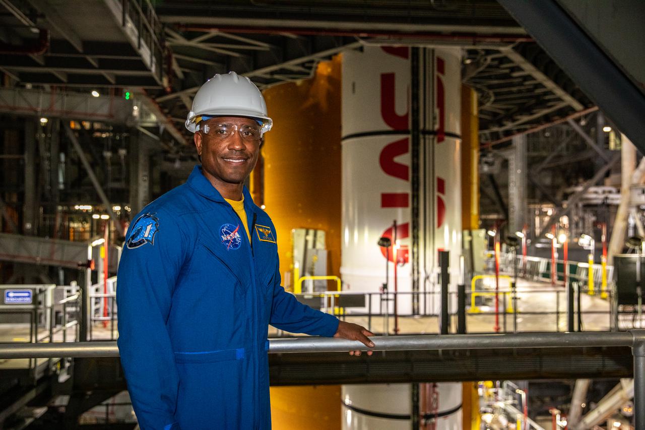 NASA astronaut Victor Glover stands inside Kennedy Space Center’s Vehicle Assembly Building on July 15, 2021, near the agency’s Space Launch System (SLS) rocket that will power the Orion spacecraft on the Artemis I mission later this year. Artemis I will be a test of Orion and SLS as an integrated system ahead of crewed flights to the Moon. Under Artemis, NASA aims to land the first woman and first person of color on the Moon and establish long-term lunar exploration.