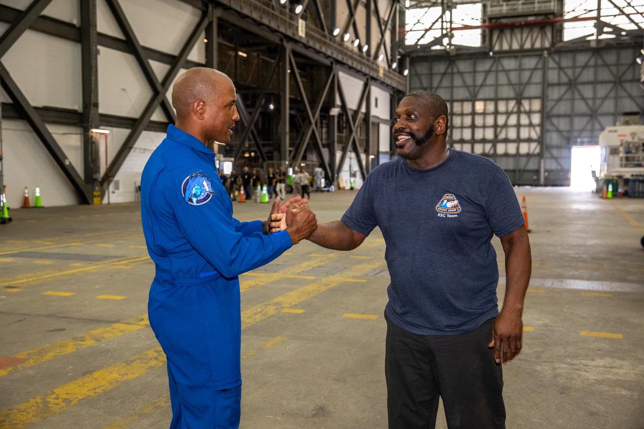 NASA astronaut Victor Glover greets Kenneth McElroy, Launch Vehicle Processing Technician with Jacobs, inside Kennedy Space Center’s Vehicle Assembly Building on July 15, 2021. Glover got a close look at NASA’s Space Launch System (SLS) rocket that will power the Orion spacecraft on the Artemis I mission later this year. Artemis I will be a test of Orion and SLS as an integrated system ahead of crewed flights to the Moon. Under Artemis, NASA aims to land the first woman and first person of color on the Moon and establish long-term lunar exploration.