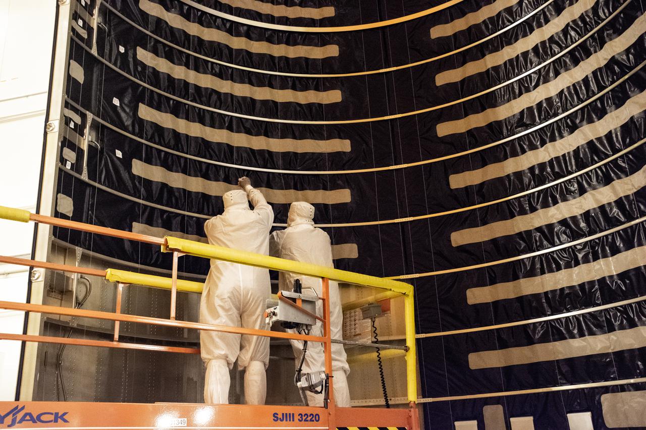 Inside the Integrated Processing Facility at Vandenberg Space Force Base in California, technicians with United Launch Alliance (ULA) remove the protective blankets from one payload fairing half for the Landsat 9 spacecraft on Aug. 2, 2021. The two halves of the ULA payload fairing will be secured around Landsat 9 to protect it during launch atop the ULA Atlas V rocket. Landsat 9 will launch on the Atlas V rocket from Space Launch Complex 3 at Vandenberg in September 2021. The launch is being managed by NASA’s Launch Services Program based at Kennedy Space Center, America’s multi-user spaceport. The Landsat 9 satellite will continue the nearly 50-year legacy of previous Landsat missions. It will monitor key natural and economic resources from orbit. Landsat 9 is managed by the agency’s Goddard Space Flight Center in Greenbelt, Maryland. The satellite will carry two instruments: the Operational Land Imager 2, which collects images of Earth’s landscapes in visible, near infrared and shortwave infrared light, and the Thermal Infrared Sensor 2, which measures the temperature of land surfaces. Like its predecessors, Landsat 9 is a joint mission between NASA and the U.S. Geological Survey. 