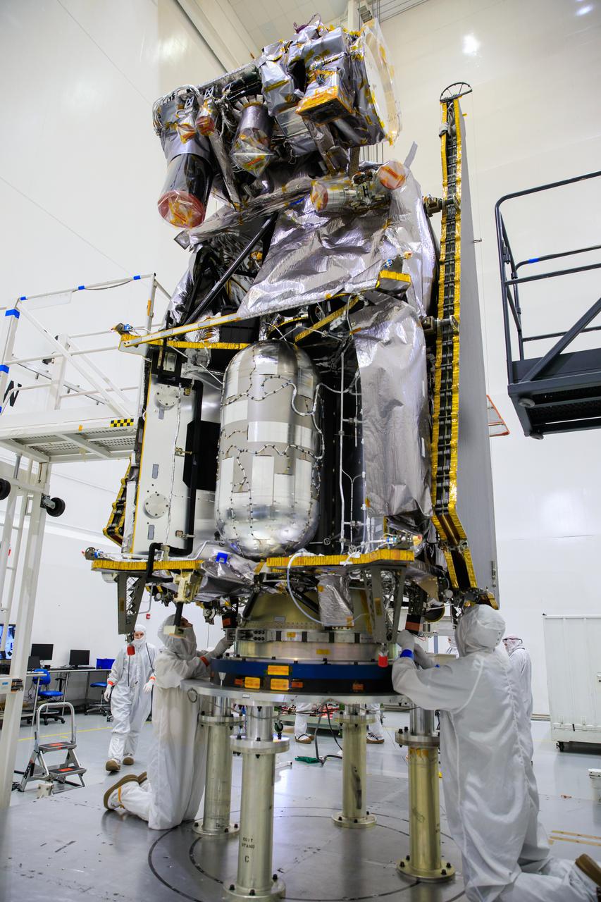Workers inside the Astrotech Space Operations Facility in Titusville, Florida, prepare NASA’s Lucy spacecraft for its lift by crane and transfer to a rotation stand on Aug. 4, 2021. Lucy is scheduled to launch no earlier than Saturday, Oct. 16, on a United Launch Alliance Atlas V 401 rocket from Launch Pad 41 at Cape Canaveral Space Force Station. NASA’s Launch Services Program based at Kennedy Space Center is managing the launch. Over its 12-year primary mission, Lucy will explore a record-breaking number of asteroids, flying by one asteroid in the solar system’s main belt and seven Trojan asteroids. Additionally, Lucy’s path will circle back to Earth three times for gravity assists, making it the first spacecraft ever to return to the vicinity of Earth from the outer solar system. 