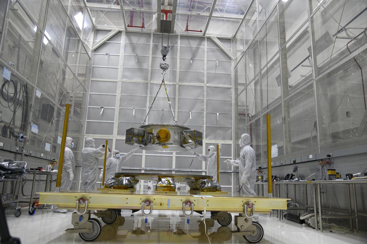 Technicians monitor the progress as a crane is used to lift the secondary payload adapter for NASA’s Landsat 9 mission onto a transporter stand at Vandenberg Space Force Base in California, on Aug. 4, 2021. The payload adapter will be transported to the Integrated Processing Facility. Several secondary payloads, called CubeSats, will launch with Landsat 9 atop a United Launch Alliance Atlas V rocket from Vandenberg in September 2021. The launch is being managed by NASA’s Launch Services Program based at Kennedy Space Center, America’s multi-user spaceport. The Landsat 9 satellite will continue the nearly 50-year legacy of previous Landsat missions. It will monitor key natural and economic resources from orbit. Landsat 9 is managed by the agency’s Goddard Space Flight Center in Greenbelt, Maryland. The satellite will carry two instruments: the Operational Land Imager 2, which collects images of Earth’s landscapes in visible, near infrared and shortwave infrared light, and the Thermal Infrared Sensor 2, which measures the temperature of land surfaces. Like its predecessors, Landsat 9 is a joint mission between NASA and the U.S. Geological Survey. 