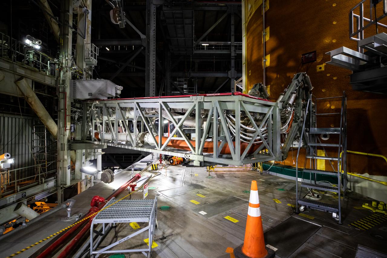 The core stage inter-tank umbilical – one of multiple connections on the mobile launcher that will provide power, communications, and pressurized gases to the rocket – is attached to the Space Launch System (SLS) core stage inside the Vehicle Assembly Building at NASA’s Kennedy Space Center in Florida on Aug. 12, 2021. Before the Orion spacecraft can be stacked atop the SLS, teams are conducting various tests to ensure the rocket can properly communicate with the ground systems equipment that will be used for launch. The first in an increasingly complex set of missions, Artemis I will test SLS and Orion as an integrated system prior to crewed flights to the Moon. Through Artemis, NASA will send the first woman and the first person of color to the lunar surface, as well as establish a sustainable presence on and around the Moon.
