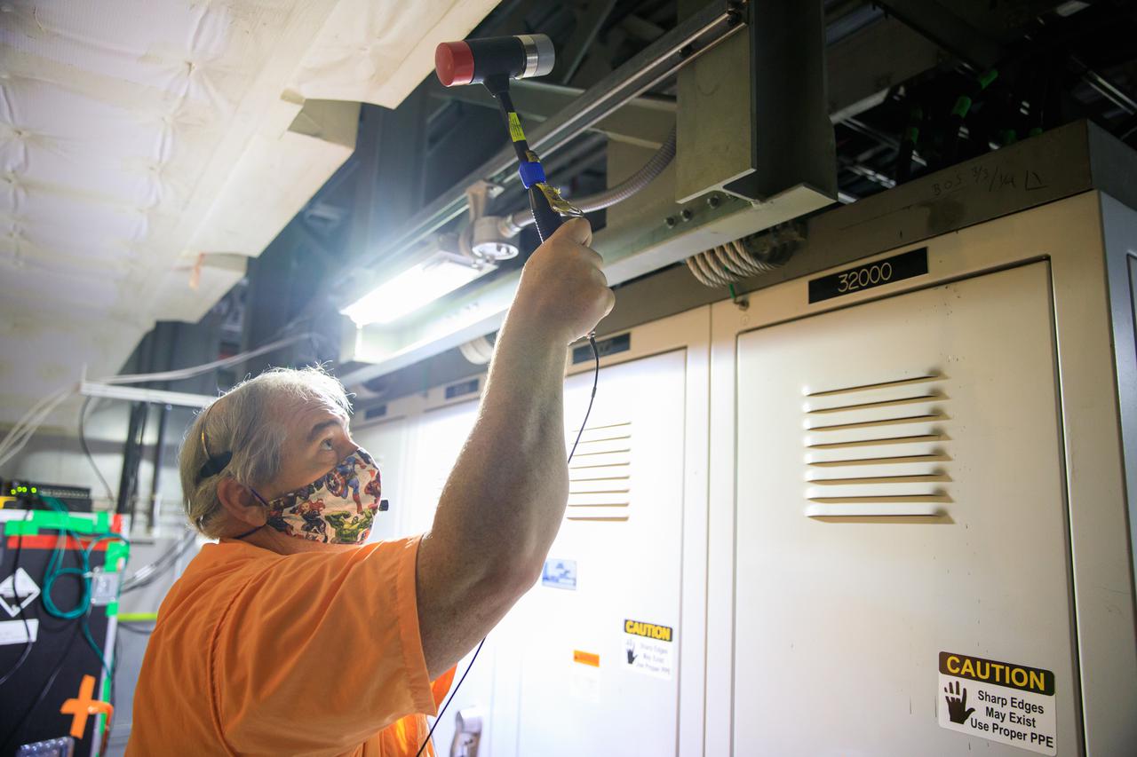An engineer with contractor Jacobs prepares for a modal tap test on the Space Launch System (SLS) rocket for Artemis I in a room under the zero deck of the mobile launcher inside the Vehicle Assembly Building at NASA’s Kennedy Space Center in Florida on Aug. 16, 2021. The Exploration Ground systems and Jacobs team, along with the SLS team from NASA’s Marshall Space Flight Center in Huntsville, Alabama, are performing the tests with support from personnel at other NASA centers. Engineers are using the mass simulator for Orion and the Orion stage adapter structural test article for the modal test. The tests will determine the different modes of vibration with the recently stacked and integrated SLS rocket before launch of the Artemis I mission. Artemis I will be an uncrewed test of the Orion spacecraft and SLS rocket as an integrated system ahead of crewed flights to the Moon. Under Artemis, NASA aims to land the first woman and first person of color on the Moon and establish sustainable lunar exploration. 