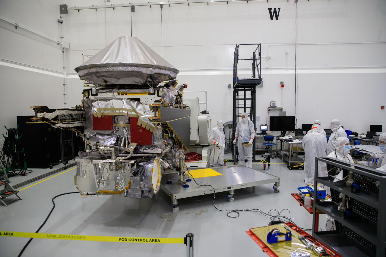 Workers inside the Astrotech Space Operations Facility in Titusville, Florida, begin to extend one of the solar arrays on NASA’s Lucy spacecraft on Aug. 19, 2021. Both solar arrays will be opened to make sure they operate correctly. In view installed on top of the spacecraft is the high gain antenna. Lucy is scheduled to launch no earlier than Saturday, Oct. 16, on a United Launch Alliance Atlas V 401 rocket from Space Launch Complex 41 at Cape Canaveral Space Force Station. NASA’s Launch Services Program based at Kennedy Space Center is managing the launch. Over its 12-year primary mission, Lucy will explore a record-breaking number of asteroids, flying by one asteroid in the solar system’s main belt and seven Trojan asteroids. Additionally, Lucy’s path will circle back to Earth three times for gravity assists, making it the first spacecraft ever to return to the vicinity of Earth from the outer solar system. 