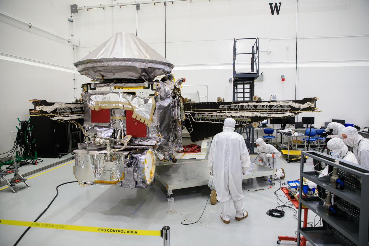 Workers inside the Astrotech Space Operations Facility in Titusville, Florida, work to open and extend one of the solar arrays on NASA’s Lucy spacecraft on Aug. 19, 2021. Both solar arrays will be opened to make sure they operate correctly. In view installed on top of the spacecraft is the high gain antenna. Lucy is scheduled to launch no earlier than Saturday, Oct. 16, on a United Launch Alliance Atlas V 401 rocket from Space Launch Complex 41 at Cape Canaveral Space Force Station. NASA’s Launch Services Program based at Kennedy Space Center is managing the launch. Over its 12-year primary mission, Lucy will explore a record-breaking number of asteroids, flying by one asteroid in the solar system’s main belt and seven Trojan asteroids. Additionally, Lucy’s path will circle back to Earth three times for gravity assists, making it the first spacecraft ever to return to the vicinity of Earth from the outer solar system.