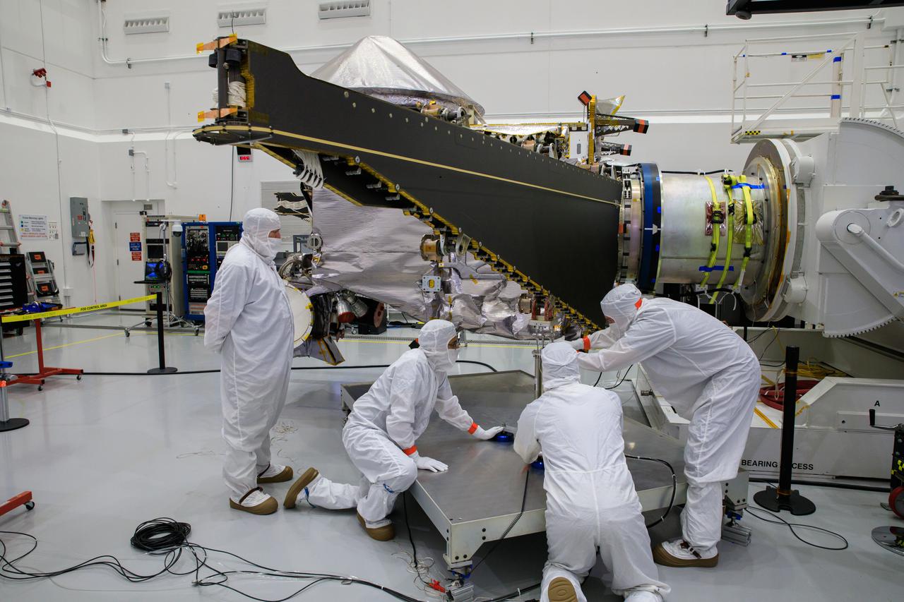 Workers inside the Astrotech Space Operations Facility in Titusville, Florida, work to open and extend one of the solar arrays on NASA’s Lucy spacecraft on Aug. 19, 2021. Both solar arrays will be opened to make sure they operate correctly. In view installed on top of the spacecraft is the high gain antenna. Lucy is scheduled to launch no earlier than Saturday, Oct. 16, on a United Launch Alliance Atlas V 401 rocket from Space Launch Complex 41 at Cape Canaveral Space Force Station. NASA’s Launch Services Program based at Kennedy Space Center is managing the launch. Over its 12-year primary mission, Lucy will explore a record-breaking number of asteroids, flying by one asteroid in the solar system’s main belt and seven Trojan asteroids. Additionally, Lucy’s path will circle back to Earth three times for gravity assists, making it the first spacecraft ever to return to the vicinity of Earth from the outer solar system.