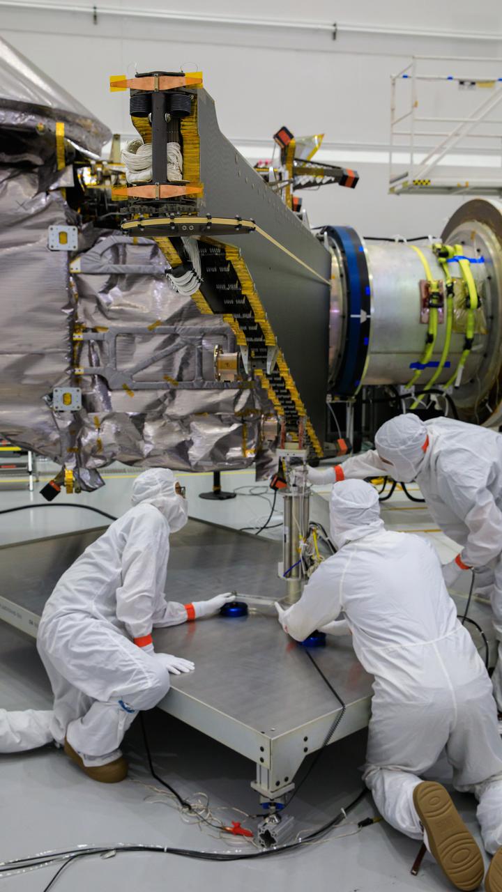 Workers inside the Astrotech Space Operations Facility in Titusville, Florida, work to open and extend one of the solar arrays on NASA’s Lucy spacecraft on Aug. 19, 2021. Both solar arrays will be opened to make sure they operate correctly. In view installed on top of the spacecraft is the high gain antenna. Lucy is scheduled to launch no earlier than Saturday, Oct. 16, on a United Launch Alliance Atlas V 401 rocket from Space Launch Complex 41 at Cape Canaveral Space Force Station. NASA’s Launch Services Program based at Kennedy Space Center is managing the launch. Over its 12-year primary mission, Lucy will explore a record-breaking number of asteroids, flying by one asteroid in the solar system’s main belt and seven Trojan asteroids. Additionally, Lucy’s path will circle back to Earth three times for gravity assists, making it the first spacecraft ever to return to the vicinity of Earth from the outer solar system. 