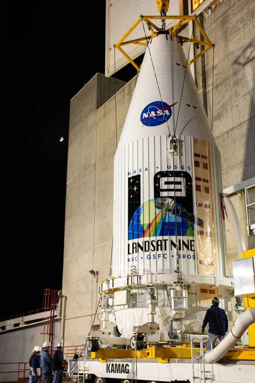 The Landsat 9 payload is hoisted out of the transfer tower at the Integration Processing Facility in preparation for transport to SLC-3 at Vandenberg Air Force Base in California.