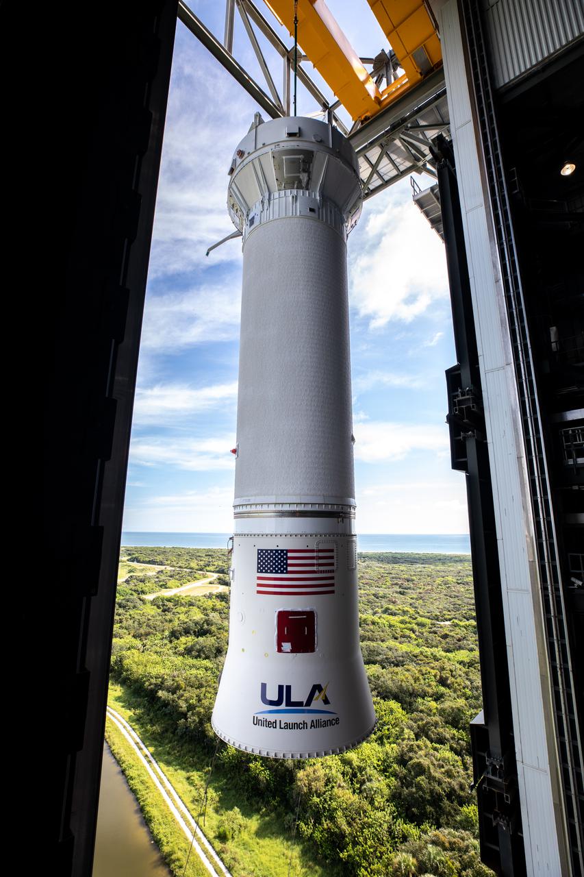 A view from inside the Vertical Integration Facility near Space Launch Complex 41 at Cape Canaveral Space Force Station in Florida, as the United Launch Alliance (ULA) Centaur stage for NASA’s Lucy mission is lifted by crane for transfer into the facility on Sept. 16, 2021. Lucy is scheduled to launch no earlier than Saturday, Oct. 16, on a ULA Atlas V 401 rocket from Pad 41. NASA’s Launch Services Program based at Kennedy Space Center is managing the launch. Over its 12-year primary mission, Lucy will explore a record-breaking number of asteroids, flying by one asteroid in the solar system’s main belt and seven Trojan asteroids. Additionally, Lucy’s path will circle back to Earth three times for gravity assists, making it the first spacecraft ever to return to the vicinity of Earth from the outer solar system. 
