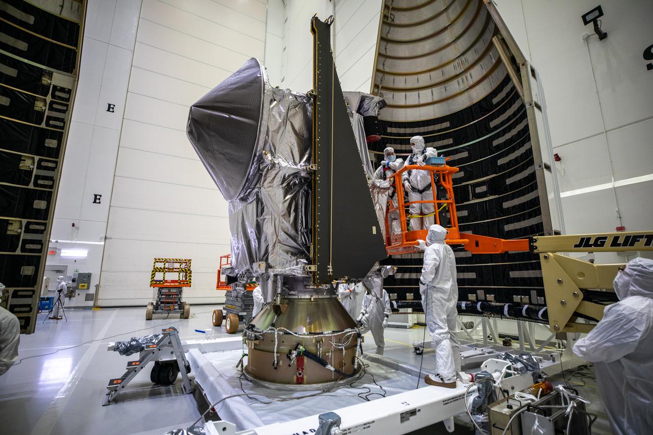 Workers inside the Astrotech Space Operations Facility in Titusville, Florida, move the first half of the United Launch Alliance (ULA) payload fairing toward NASA’s Lucy spacecraft on Sept. 30, 2021. The payload fairing will encapsulate and protect the spacecraft during launch and ascent. Lucy is scheduled to launch no earlier than Saturday, Oct. 16, on a ULA Atlas V 401 rocket from Space Launch Complex 41 at Cape Canaveral Space Force Station. NASA’s Launch Services Program based at Kennedy Space Center is managing the launch. Over its 12-year primary mission, Lucy will explore a record-breaking number of asteroids, flying by one asteroid in the solar system’s main belt and seven Trojan asteroids. Additionally, Lucy’s path will circle back to Earth three times for gravity assists, making it the first spacecraft ever to return to the vicinity of Earth from the outer solar system. 