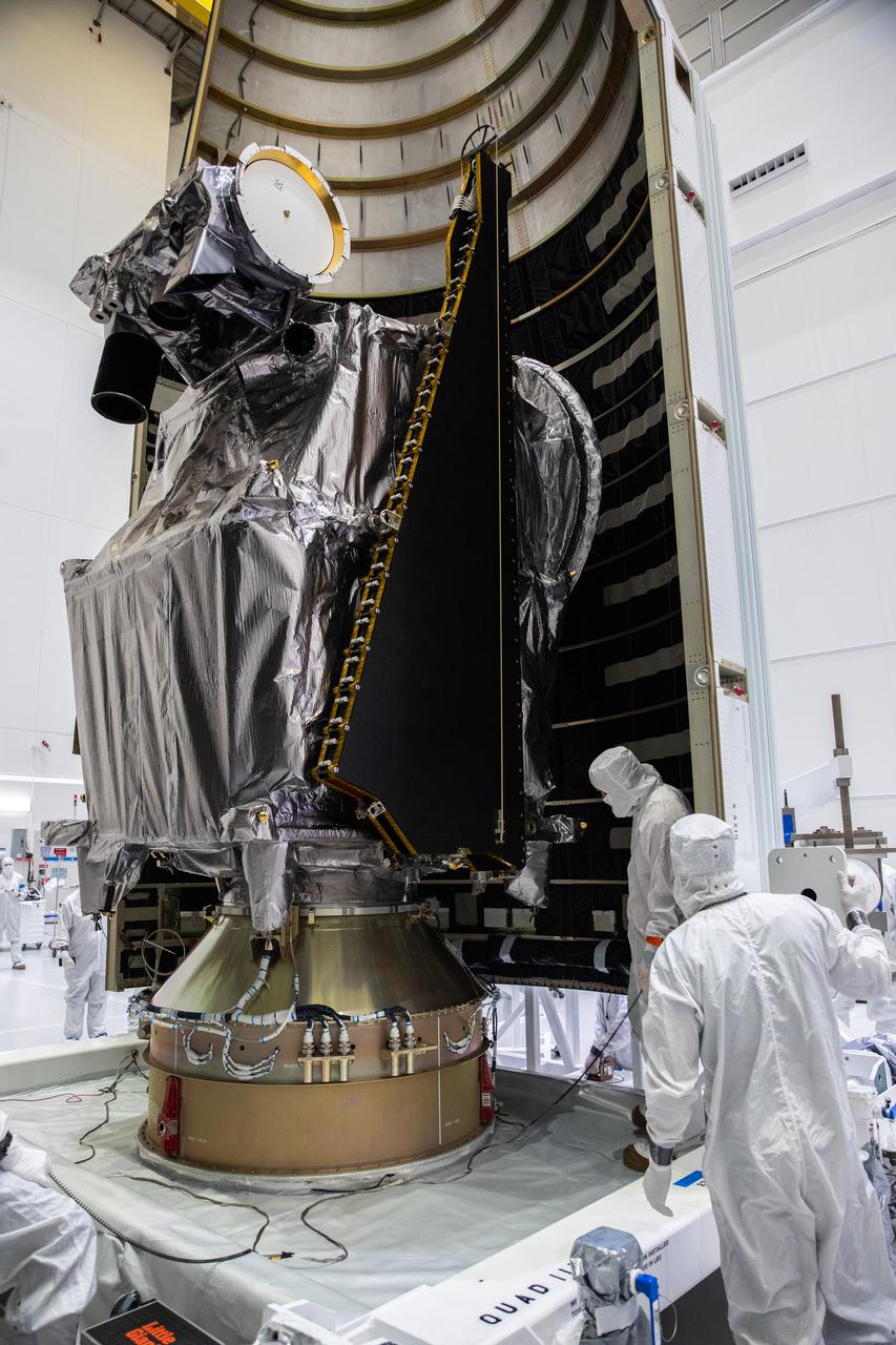 Workers inside the Astrotech Space Operations Facility in Titusville, Florida, move the first half of the United Launch Alliance (ULA) payload fairing toward NASA’s Lucy spacecraft on Sept. 30, 2021. The payload fairing will encapsulate and protect the spacecraft during launch and ascent. Lucy is scheduled to launch no earlier than Saturday, Oct. 16, on a ULA Atlas V 401 rocket from Space Launch Complex 41 at Cape Canaveral Space Force Station. NASA’s Launch Services Program based at Kennedy Space Center is managing the launch. Over its 12-year primary mission, Lucy will explore a record-breaking number of asteroids, flying by one asteroid in the solar system’s main belt and seven Trojan asteroids. Additionally, Lucy’s path will circle back to Earth three times for gravity assists, making it the first spacecraft ever to return to the vicinity of Earth from the outer solar system. 