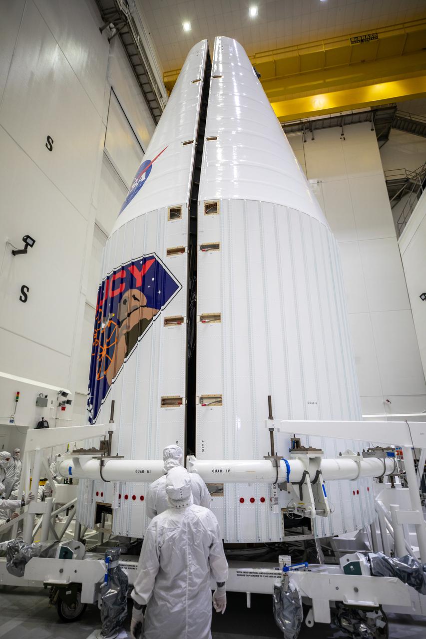 Inside the Astrotech Space Operations Facility in Titusville, Florida, workers help secure both halves of the United Launch Alliance (ULA) payload fairing around NASA’s Lucy spacecraft on Sept. 30, 2021. The payload fairing will encapsulate and protect the spacecraft during launch and ascent. Lucy is scheduled to launch no earlier than Saturday, Oct. 16, on a ULA Atlas V 401 rocket from Space Launch Complex 41 at Cape Canaveral Space Force Station. NASA’s Launch Services Program based at Kennedy Space Center is managing the launch. Over its 12-year primary mission, Lucy will explore a record-breaking number of asteroids, flying by one asteroid in the solar system’s main belt and seven Trojan asteroids. Additionally, Lucy’s path will circle back to Earth three times for gravity assists, making it the first spacecraft ever to return to the vicinity of Earth from the outer solar system. 