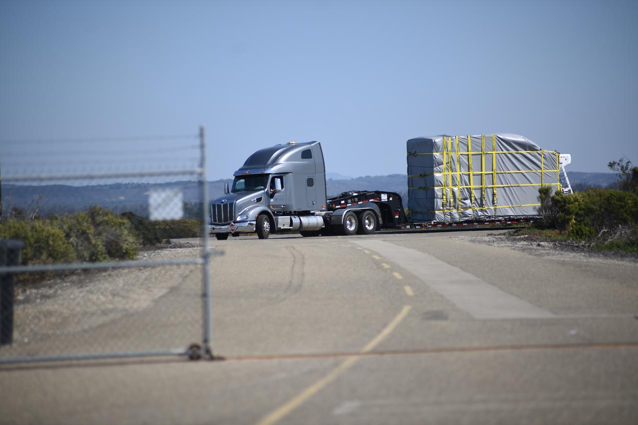 NASA’s Double Asteroid Redirection Test (DART) spacecraft, packed in its shipping container, arrives by truck at the entrance to Vandenberg Space Force Base in California on Oct. 2, 2021. DART will be transported to the Astrotech Space Operations Facility where workers will put the spacecraft through a series of final tests and checkouts to confirm it is ready for launch. DART is the first mission to test technologies for preventing an impact of Earth by a hazardous asteroid. The mission is targeted to launch on Nov. 23, 2021, aboard a SpaceX Falcon 9 rocket from Vandenberg. NASA’s Launch Services Program, based at Kennedy Space Center, America’s multi-user spaceport, is managing the launch. 