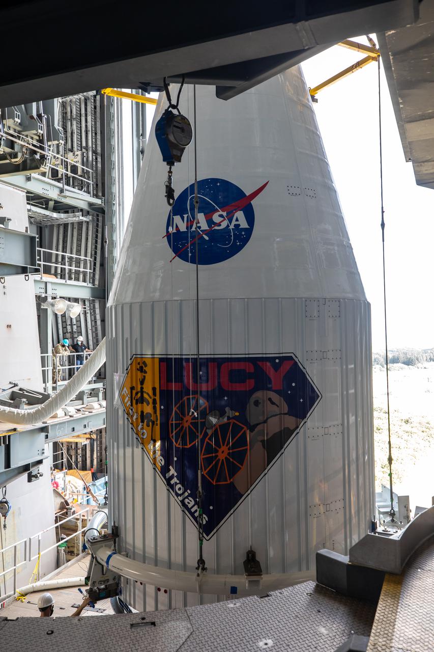 Workers assist as the payload fairing containing NASA’s Lucy spacecraft is lowered onto the United Launch Alliance (ULA) Atlas V Centaur second stage in the Vertical Integration Facility at Space Launch Complex 41 at Cape Canaveral Space Force Base in Florida on Oct. 7, 2021. Lucy is scheduled to launch no earlier than Saturday, Oct. 16, on the ULA Atlas V 401 rocket from Launch Pad 41. NASA’s Launch Services Program, based at Kennedy Space Center, America’s premier multi-user spaceport, is managing the launch. Over its 12-year primary mission, Lucy will explore a record-breaking number of asteroids, flying by one asteroid in the solar system’s main belt and seven Trojan asteroids. Additionally, Lucy’s path will circle back to Earth three times for gravity assists, making it the first spacecraft ever to return to the vicinity of Earth from the outer solar system.
