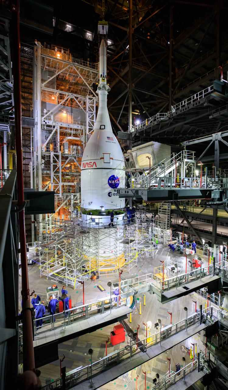 The Orion spacecraft for NASA’s Artemis I mission, fully assembled with its launch abort system, is lowered on top of the Space Launch System (SLS) rocket in High Bay 3 of the Vehicle Assembly Building at Kennedy Space Center in Florida on Oct. 20, 2021. The stacking of Orion on top of the SLS completes assembly for the Artemis I flight test. Teams will begin conducting a series of verification tests ahead of rolling out to Launch Complex 39B for the Wet Dress Rehearsal. Artemis I will be an uncrewed test flight of the Orion spacecraft and Space Launch System rocket as an integrated system ahead of crewed flights to the Moon. Under Artemis, NASA aims to land the first woman and first person of color on the Moon and establish sustainable lunar exploration. 