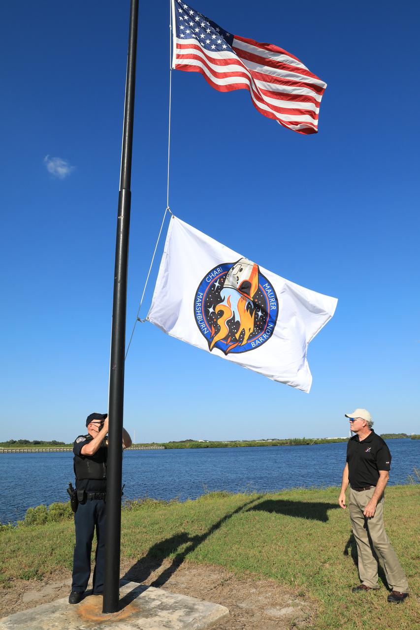 The SpaceX Crew-3 flag is raised below the American flag near the News Center countdown clock at NASA’s Kennedy Space Center in Florida on Oct. 26, 2021. The SpaceX Falcon 9 with Crew Dragon atop is scheduled to launch no earlier than Nov. 6, at 11:36 p.m. EDT from Launch Complex 39A at Kennedy. Crew Dragon will carry four astronauts to the International Space Station for NASA’s Commercial Crew Program. Crew-3 is the third crew rotation flight to the space station, and the first flight of a new Crew Dragon spacecraft. 