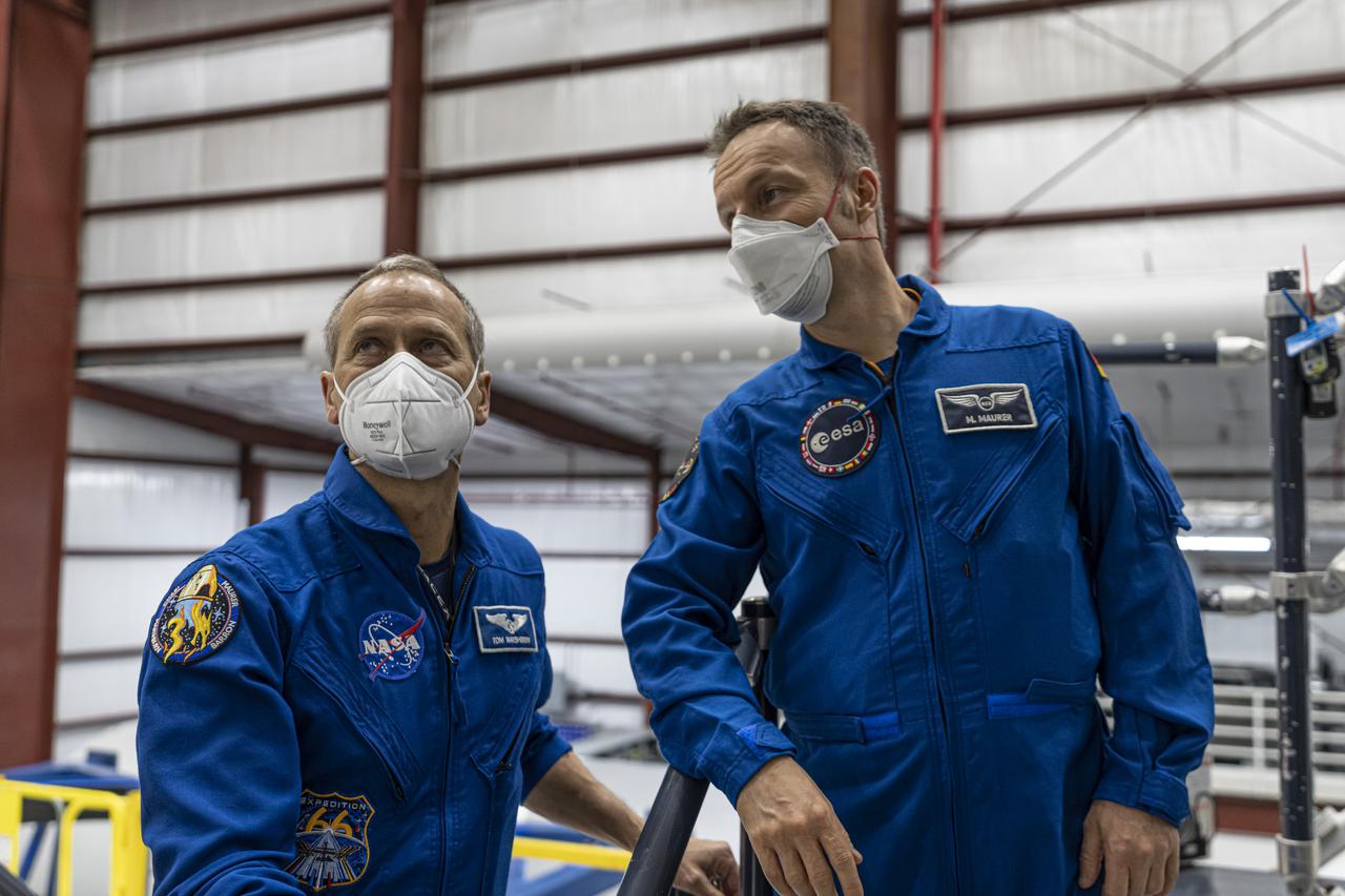 SpaceX Crew-3 NASA astronaut Tom Marshburn, left, and Matthias Maurer, an astronaut with the European Space Agency, are inside the SpaceX horizontal processing facility near Launch Complex 39A at Kennedy Space Center in Florida on Oct. 26, 2021. The astronauts are viewing the Falcon 9 rocket with Crew Dragon before rollout to the launch pad, which occurred on Oct. 27. The four-person crew will launch aboard the Crew Dragon atop the Falcon 9 on Oct. 31 to the International Space Station. Launch is targeted for 2:21 a.m. EDT from Pad 39A. Crew-3 is the third crew rotation flight to the space station for NASA’s Commercial Crew Program, and the first flight of a new Crew Dragon spacecraft.