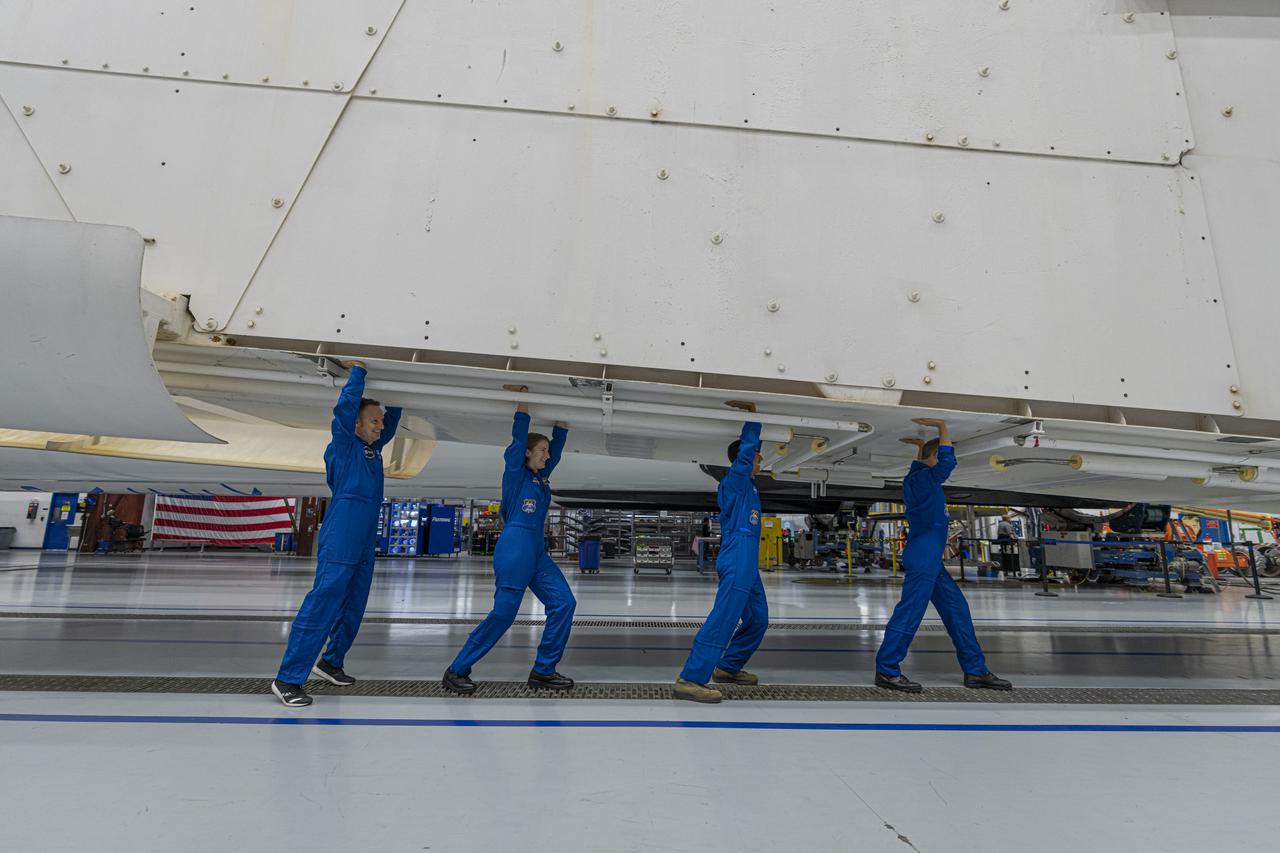 NASA’s SpaceX Crew-3 astronauts are inside the SpaceX horizontal processing facility near Launch Complex 39A at Kennedy Space Center in Florida on Oct. 26, 2021. In this view, they simulate holding up the Falcon 9 rocket on its transporter before rollout to Launch Complex 39A, which occurred on Oct. 27. From left are Matthias Maurer, with the European Space Agency, and NASA astronauts Kayla Barron, Raja Chari, and Tom Marshburn. The four-person crew will launch aboard the Crew Dragon atop the Falcon 9 on Oct. 31 to the International Space Station. Launch is targeted for 2:21 a.m. EDT from Pad 39A. Crew-3 is the third crew rotation flight to the space station for NASA’s Commercial Crew Program, and the first flight of a new Crew Dragon spacecraft.