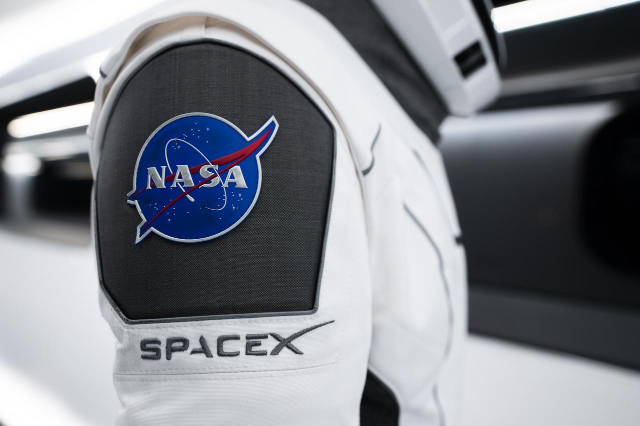 NASA’s SpaceX Crew-3 astronauts participate in a countdown dress rehearsal at the agency’s Kennedy Space Center in Florida on Oct. 28, 2021, to prepare for the upcoming Crew-3 launch. In this view is a close-up of the NASA and SpaceX embroidered emblems on the SpaceX spacesuit worn by NASA astronaut Kayla Barron. Barron is inside the crew access arm leading to the company’s Crew Dragon spacecraft during the rehearsal. The four-person crew will launch aboard the Crew Dragon atop the Falcon 9 on Oct. 31 to the International Space Station. Launch is targeted for 2:21 a.m. EDT from Pad 39A. Crew-3 is the third crew rotation flight to the space station for NASA’s Commercial Crew Program, and the first flight of a new Crew Dragon spacecraft. 