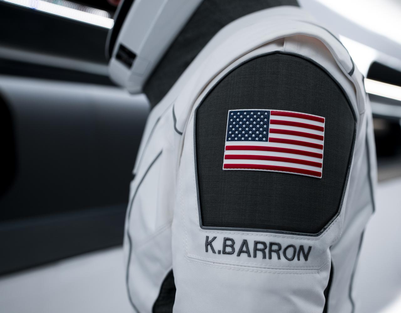 NASA’s SpaceX Crew-3 astronauts participate in a countdown dress rehearsal at the agency’s Kennedy Space Center in Florida on Oct. 28, 2021, to prepare for the upcoming Crew-3 launch. In this view is a close-up of the American flag and Kayla Barron’s name embroidered on the SpaceX spacesuit she is wearing. Barron is inside the crew access arm leading to the company’s Crew Dragon spacecraft during the rehearsal. The four-person crew will launch aboard the Crew Dragon atop the Falcon 9 on Oct. 31 to the International Space Station. Launch is targeted for 2:21 a.m. EDT from Pad 39A. Crew-3 is the third crew rotation flight to the space station for NASA’s Commercial Crew Program, and the first flight of a new Crew Dragon spacecraft. 