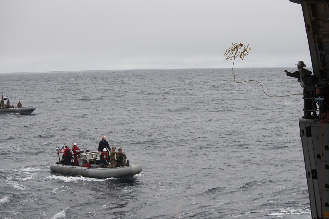 A sailor with the USS John P. Murtha (LPD 26) throws a tending line to a Navy diver assigned to Explosive Ordnance Disposal (EOD) Expeditionary Support Unit (ESU) One during Underway Recovery Test 9 (URT-9). The diver will attach the line to a mock Orion capsule so it can be brought into the well deck of the ship. During the weeklong test, NASA’s Landing and Recovery team is performing their final mission certification ahead of Artemis I.